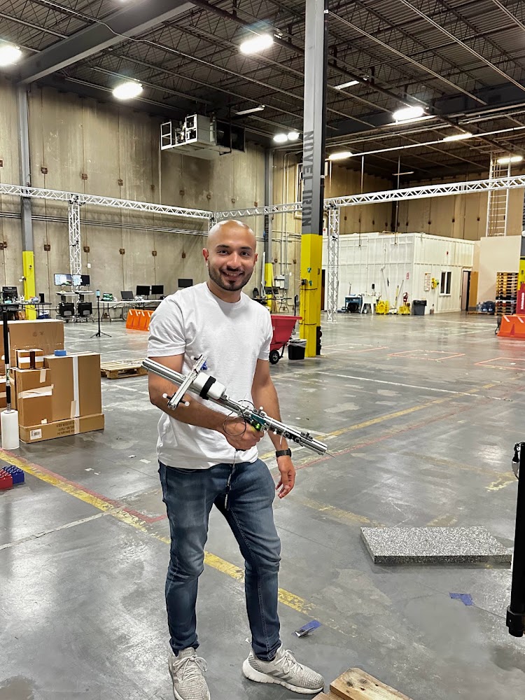 Jerrar Bukhari holding a motion-capture probe in the OptiTrak lab at the AutoGuide warehouse
